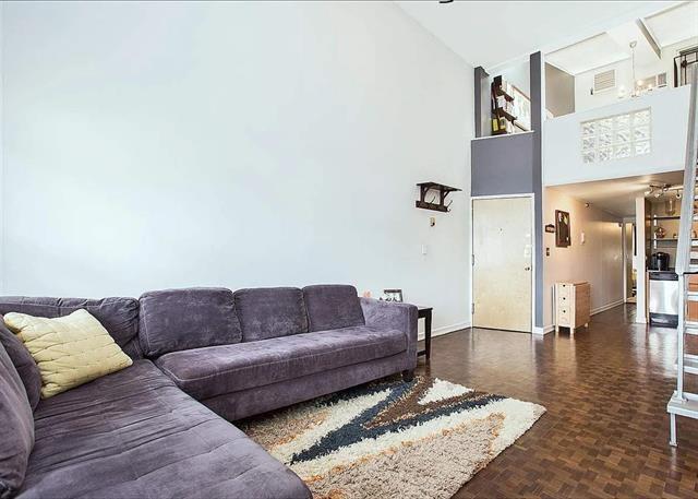 living room featuring dark parquet floors and a high ceiling