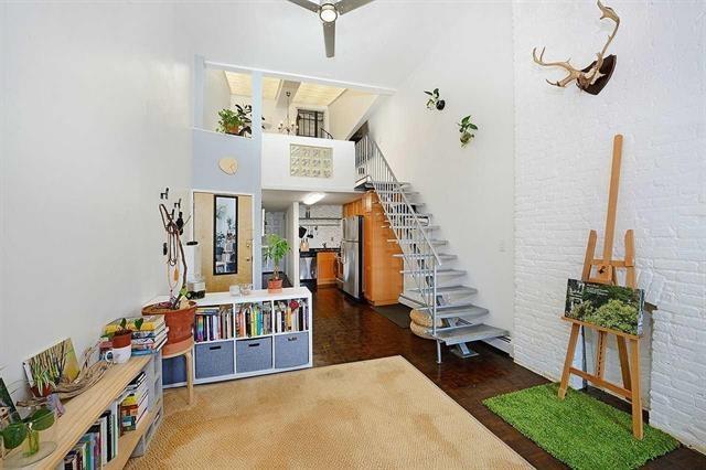 stairs featuring a towering ceiling and brick wall