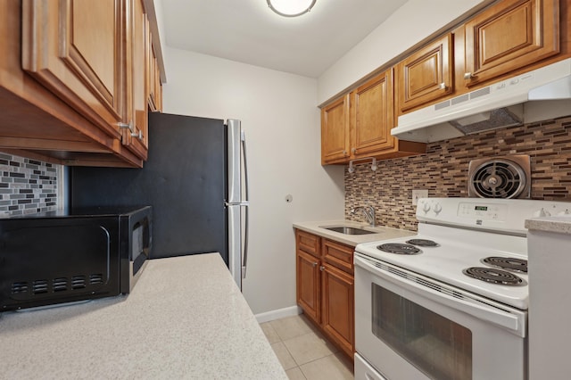 kitchen with sink, backsplash, light tile patterned floors, and white range with electric cooktop