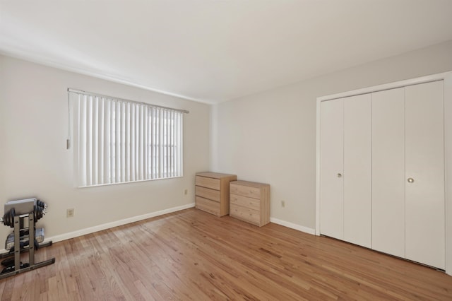 unfurnished bedroom with light wood-type flooring and a closet