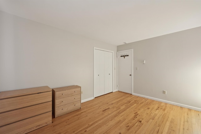 unfurnished bedroom featuring light hardwood / wood-style flooring and a closet