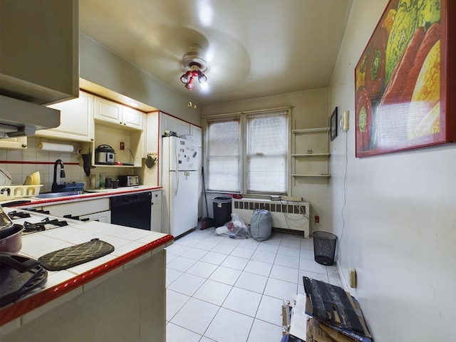 kitchen with tile countertops, dishwasher, white cabinets, white fridge, and radiator heating unit