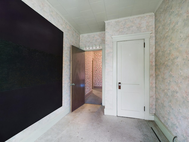 empty room featuring light carpet and crown molding