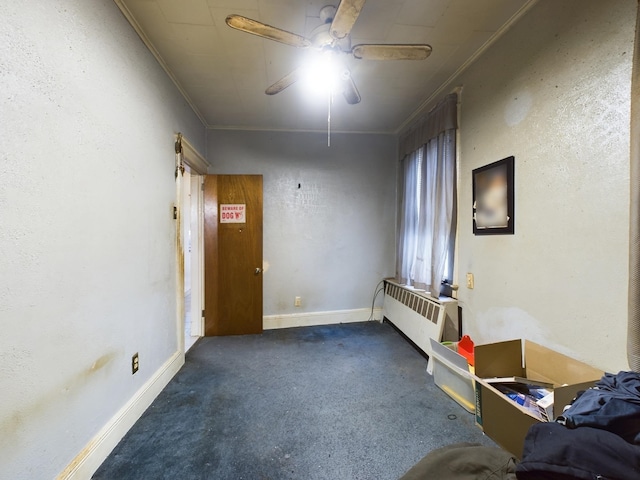 carpeted spare room featuring ceiling fan, radiator heating unit, and crown molding