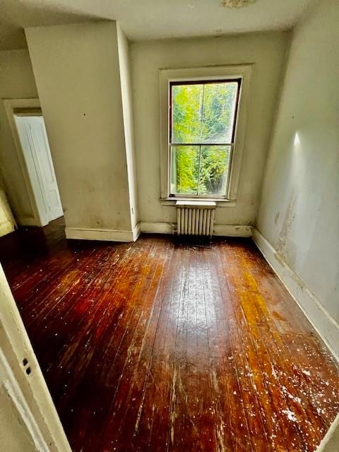 unfurnished room with hardwood / wood-style flooring and radiator