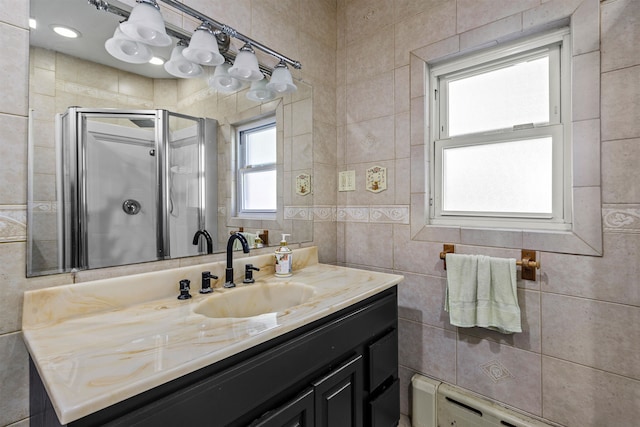 bathroom featuring walk in shower, vanity, a baseboard heating unit, and tile walls