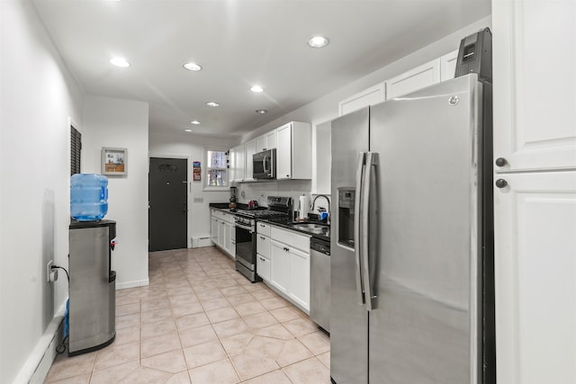 kitchen featuring white cabinets, stainless steel appliances, baseboard heating, and sink