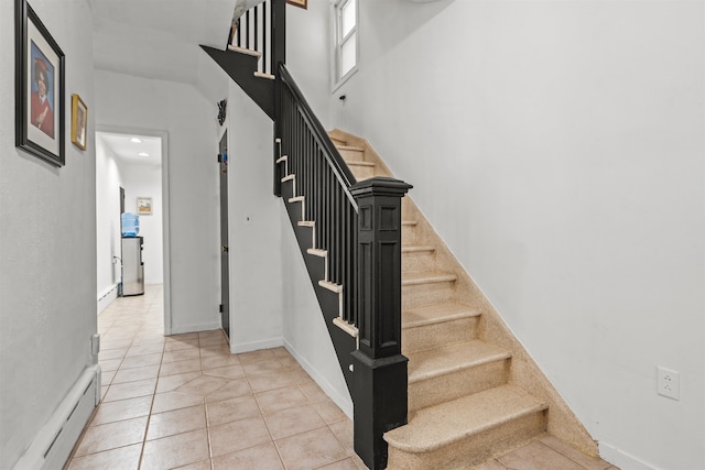 stairway featuring a baseboard radiator and tile patterned floors