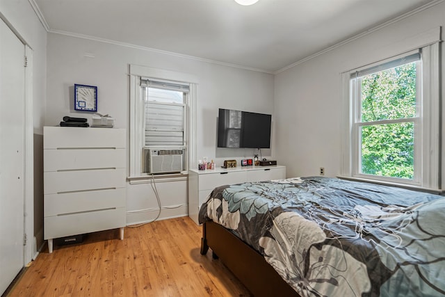 bedroom with ornamental molding and light hardwood / wood-style flooring