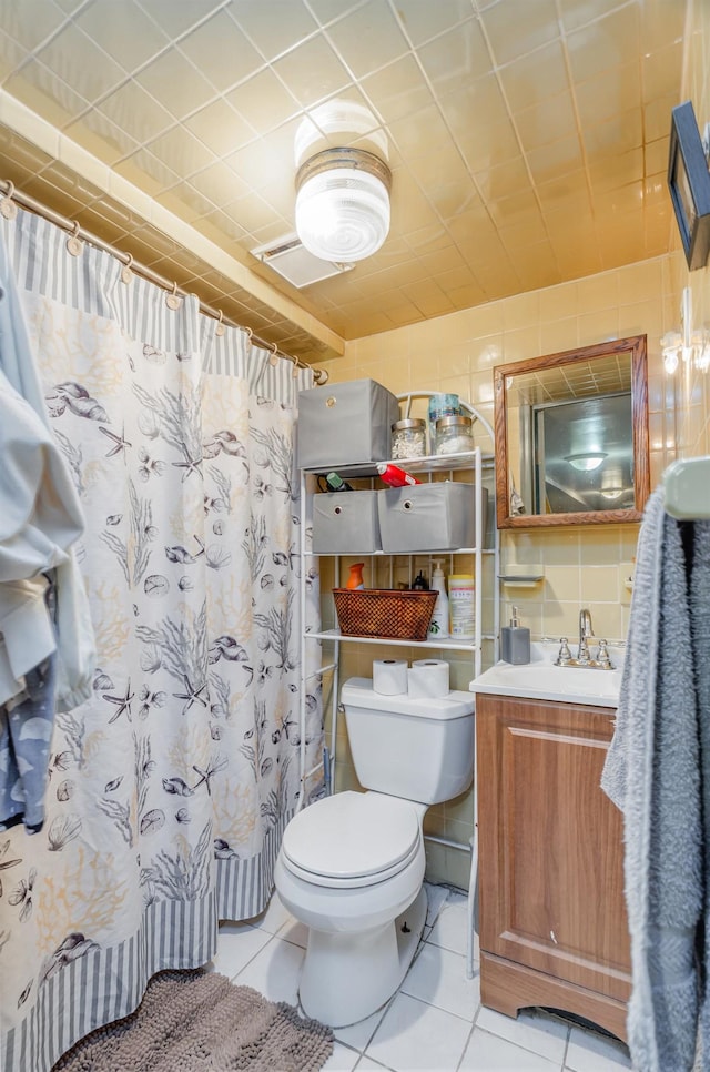 bathroom with curtained shower, vanity, toilet, and tile patterned floors