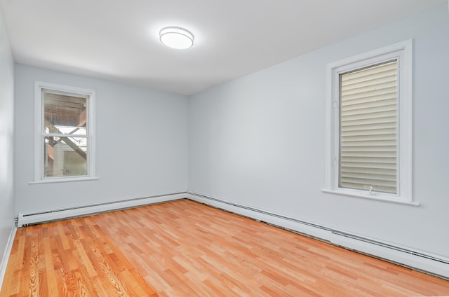 unfurnished room featuring baseboard heating, a baseboard radiator, and wood finished floors