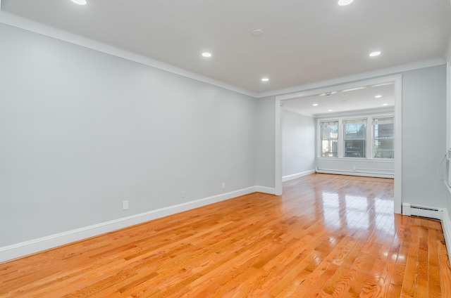 spare room featuring light wood-style floors, recessed lighting, baseboards, and a baseboard radiator