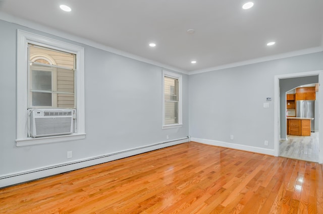 unfurnished room with arched walkways, baseboards, light wood-style flooring, a baseboard heating unit, and recessed lighting