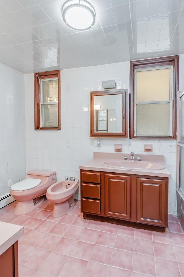 full bath featuring tile walls, toilet, a bidet, vanity, and tile patterned flooring