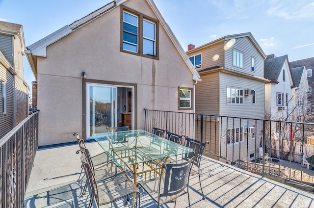 back of house with outdoor dining space and stucco siding