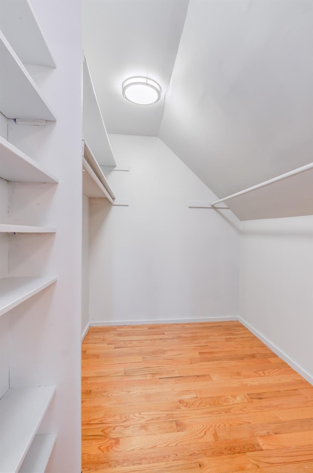 spacious closet featuring lofted ceiling and wood finished floors