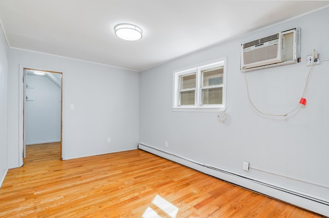 spare room with a wall mounted AC, a baseboard radiator, and light wood-style flooring