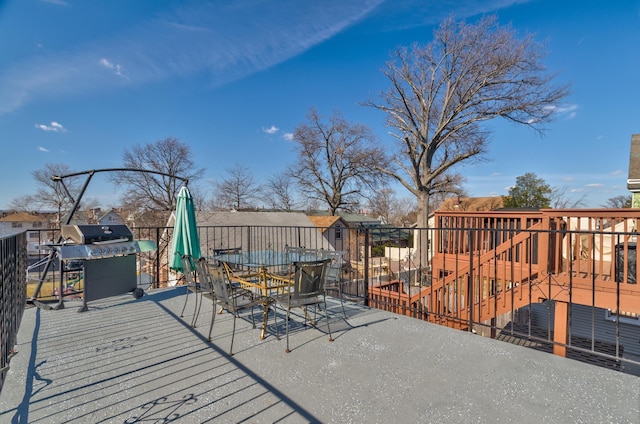 wooden deck with outdoor dining space and grilling area