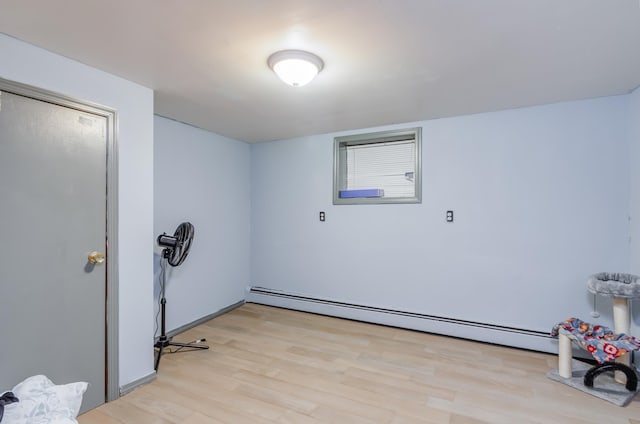 interior space with a baseboard heating unit and light wood-style flooring