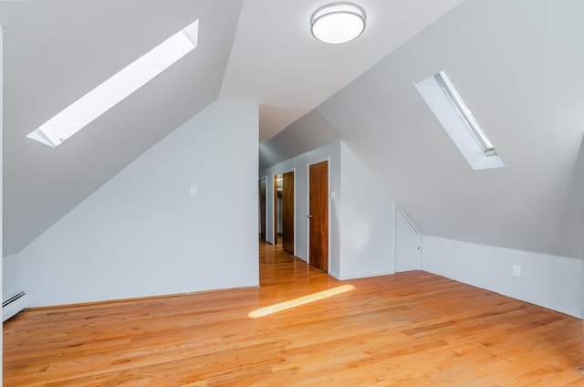 bonus room featuring lofted ceiling with skylight and light wood-style flooring