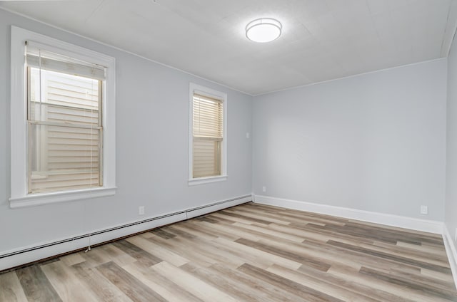 unfurnished room with light wood finished floors, baseboards, and baseboard heating