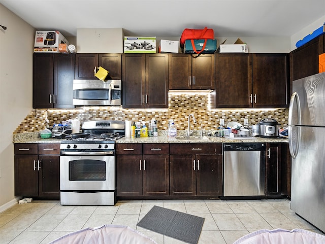 1201 Summit Ave Unit 402, Jersey City, NJ 07307 - kitchen featuring stainless steel appliances, light tile patterned floors, backsplash, and dark brown cabinetry