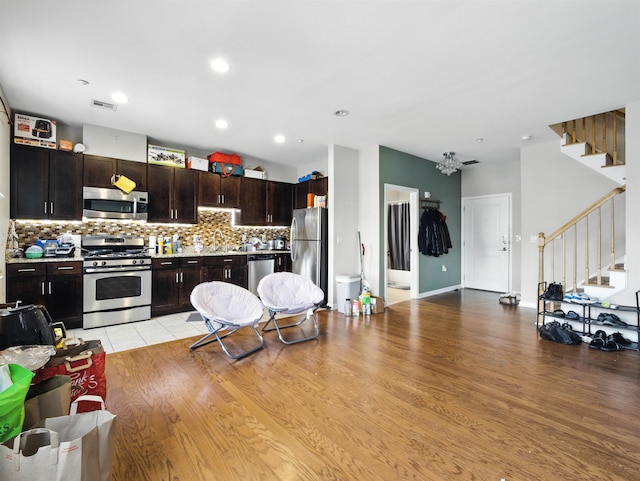 1201 Summit Ave Unit 402, Jersey City, NJ 07307 - kitchen featuring appliances with stainless steel finishes, decorative backsplash, light countertops, open floor plan, and a chandelier