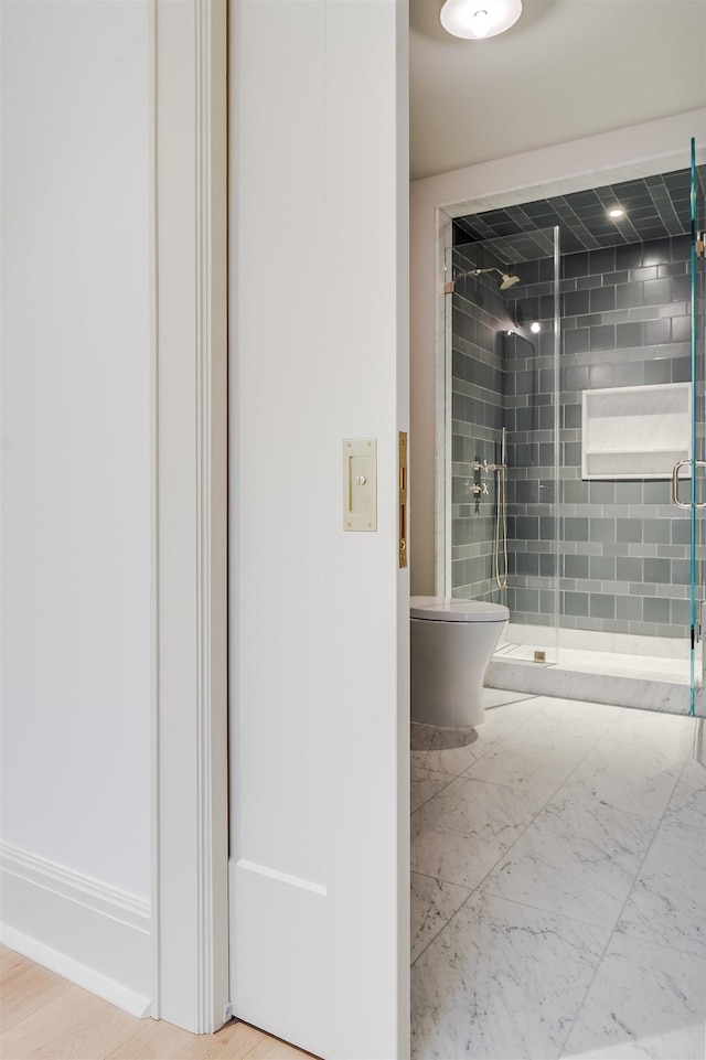 bathroom with a shower stall and toilet