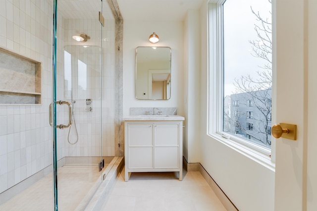 bathroom with baseboards, a stall shower, and vanity