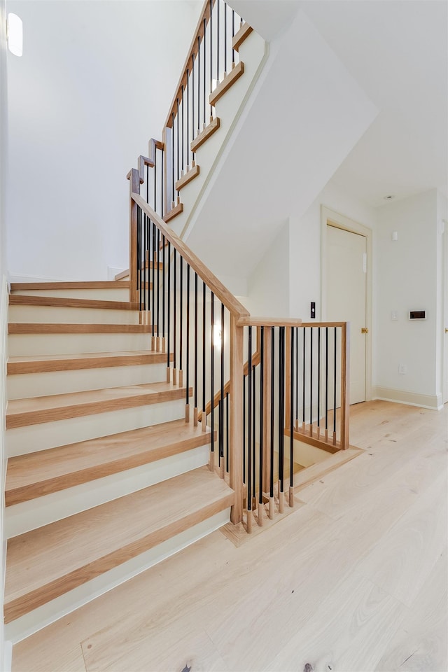 stairway with baseboards and wood finished floors