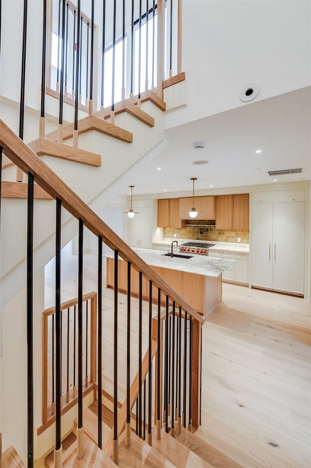 stairs with visible vents, recessed lighting, and wood finished floors