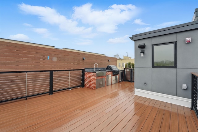 deck with grilling area, a sink, and exterior kitchen