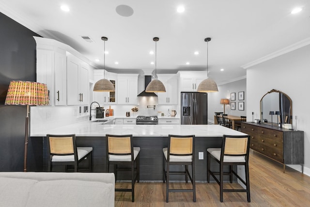 23 Manhattan Ave Unit 1, Jersey City, NJ 07307 - kitchen featuring appliances with stainless steel finishes, a peninsula, a sink, wall chimney range hood, and ornamental molding
