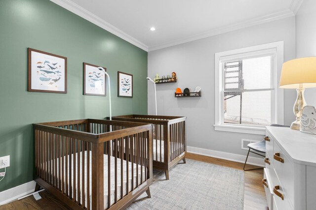 23 Manhattan Ave Unit 1, Jersey City, NJ 07307 - bedroom featuring crown molding, wood finished floors, baseboards, recessed lighting, and a crib