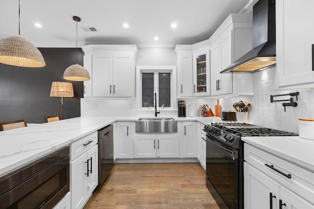 23 Manhattan Ave Unit 1, Jersey City, NJ 07307 - kitchen with wall chimney exhaust hood, black appliances, a sink, white cabinets, and tasteful backsplash