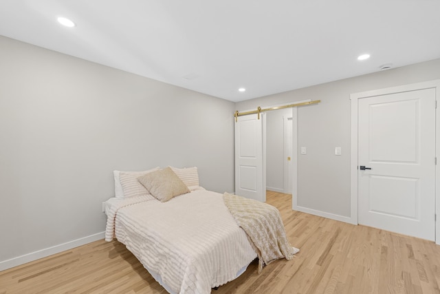 312 Garfield Ave Unit 2, Jersey City, NJ 07305 - bedroom featuring a barn door, light wood-type flooring, and recessed lighting