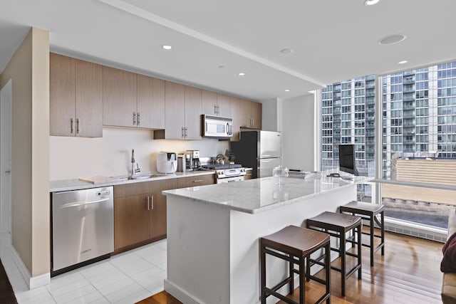 20 Newport Pkwy Unit 1108, Jersey City, NJ 07310 - kitchen with a sink, stainless steel appliances, a kitchen bar, a center island, and a wall of windows