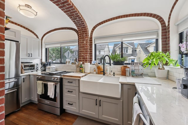 7619 5th Ave, North Bergen, NJ 07047 - kitchen with stainless steel appliances, gray cabinets, tasteful backsplash, dark wood finished floors, and light stone countertops