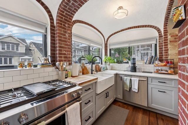 7619 5th Ave, North Bergen, NJ 07047 - kitchen featuring appliances with stainless steel finishes, dark wood finished floors, light countertops, tasteful backsplash, and gray cabinetry