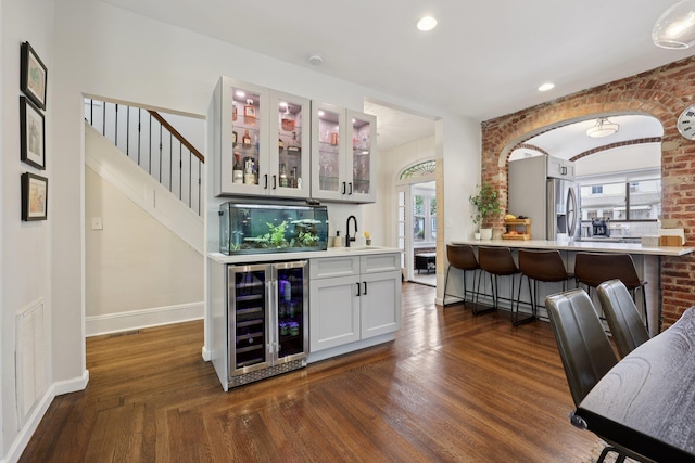 7619 5th Ave, North Bergen, NJ 07047 - indoor wet bar featuring wine cooler, brick wall, stainless steel refrigerator with ice dispenser, recessed lighting, and stairway