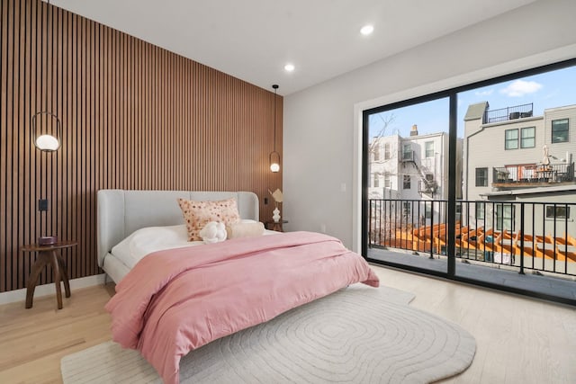 81 Webster Ave Unit 1, Jersey City, NJ 07307 - bedroom with access to exterior, wood finished floors, recessed lighting, an accent wall, and wood walls
