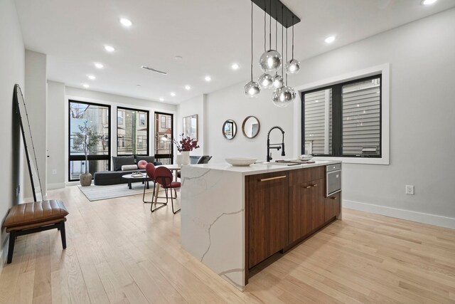 81 Webster Ave Unit 1, Jersey City, NJ 07307 - kitchen featuring modern cabinets, a spacious island, light wood-type flooring, open floor plan, and recessed lighting