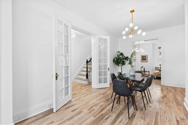 48 Armstrong Ave, Jersey City, NJ 07305 - dining space featuring a chandelier, light wood-type flooring, french doors, stairs, and lofted ceiling