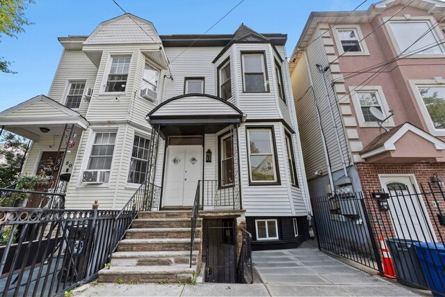 48 Armstrong Ave, Jersey City, NJ 07305 - view of front of home featuring a fenced front yard, a gate, cooling unit, and entry steps