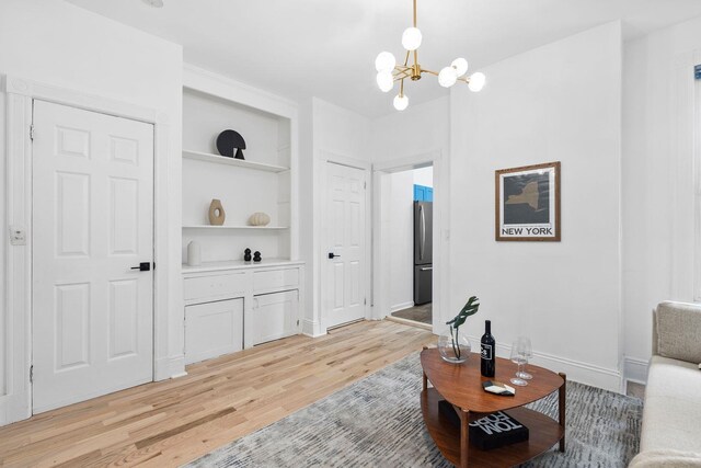 48 Armstrong Ave, Jersey City, NJ 07305 - living area featuring light wood finished floors, built in features, and a chandelier