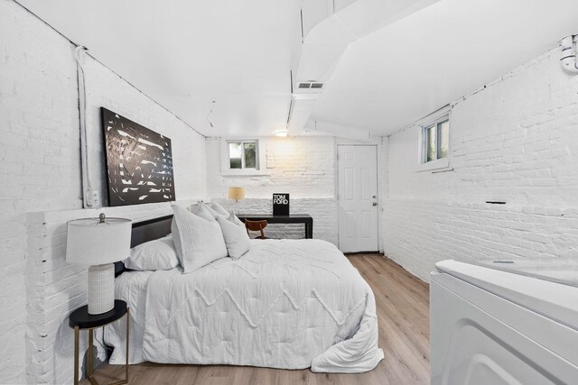 48 Armstrong Ave, Jersey City, NJ 07305 - bedroom with brick wall, wood finished floors, and multiple windows