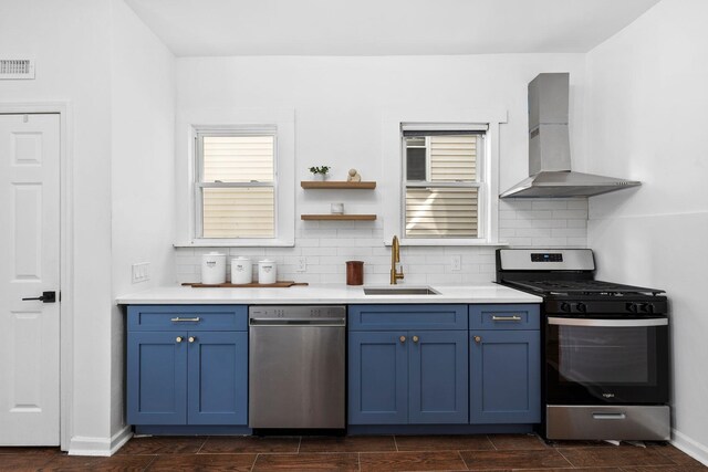 48 Armstrong Ave, Jersey City, NJ 07305 - kitchen with stainless steel appliances, wall chimney range hood, blue cabinetry, light countertops, and backsplash