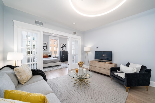 living room with light hardwood / wood-style floors and french doors