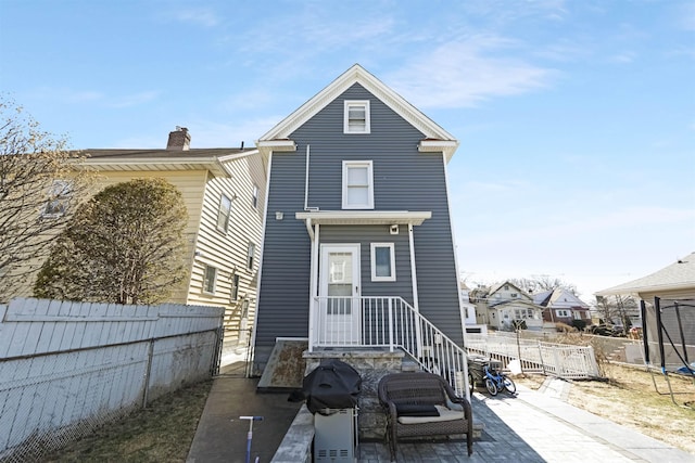 rear view of house with a patio and fence