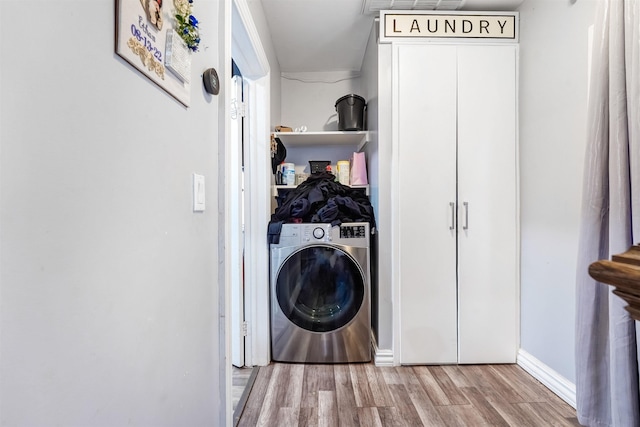 laundry area featuring baseboards, washer / dryer, wood finished floors, and laundry area